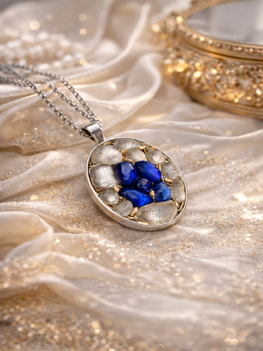 Silver pendant with blue stones on a textured fabric background