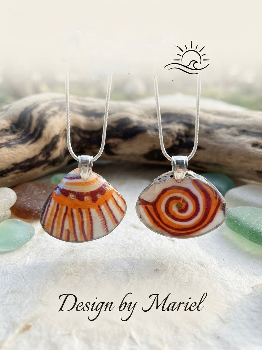 Two oval pendant necklaces with seashell-inspired designs, one striped orange, brown, and white and the other a spiral pattern in orange, brown, and white, hanging on silver chains against a beach-themed background with driftwood and sea glass. A logo for 'Design by Mariel' is visible.